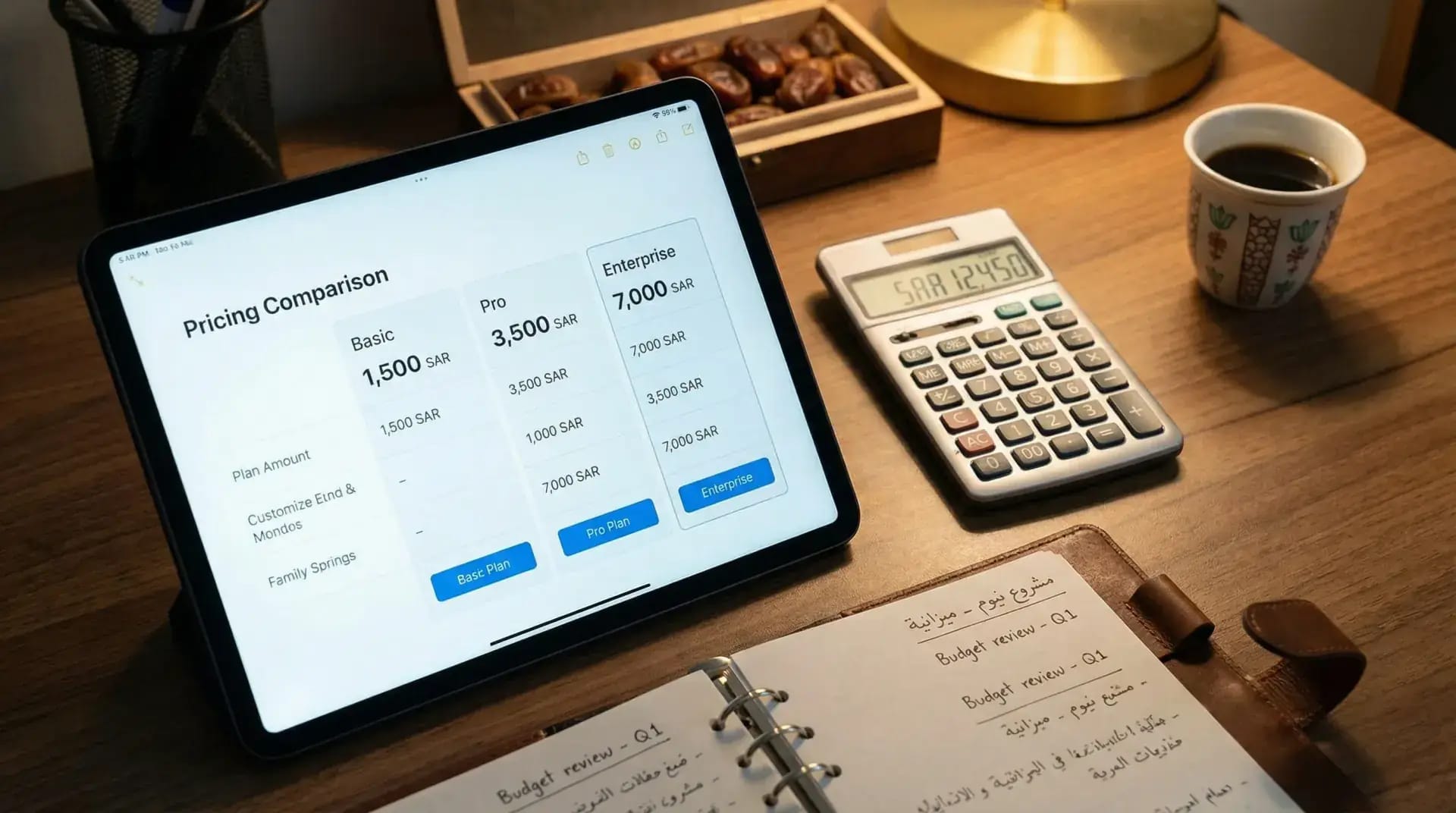 Tablet showing pricing comparison with calculator and notes on a wooden desk